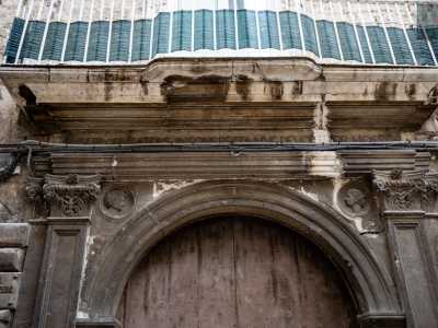 I finti capitelli corinzi reggono la trabeazione, sulla quale si trova la scritta in latino dum probus atque insons recta huc devotior hospes (�L�ospite � qui gradito purch� giusto e senza colpa�)